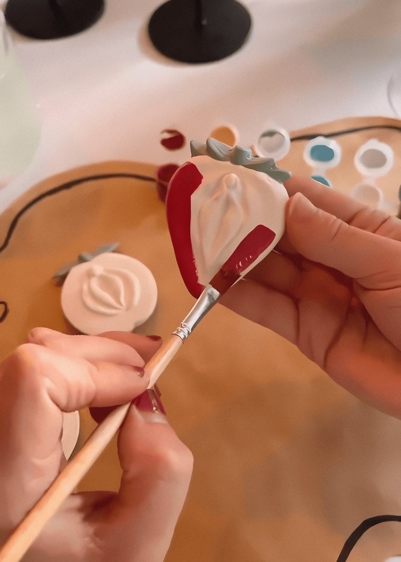 Ceramic yoni magnet being painted at party